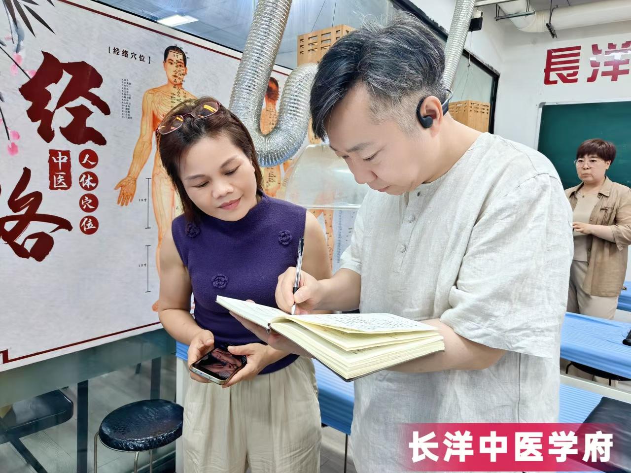 课间休息学员在认真的做笔记,老师细心的给学员纠正。
